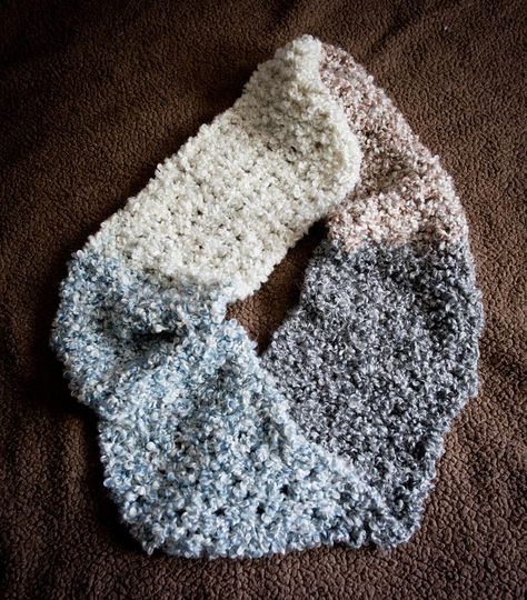 "The Homespun Infinity Scarf is fluffy and warm. It is crocheted with a boucle yarn for a nice texture, in an openwork stitch to keep it light. The yarn is self-striping in four colors, black, ivory, brown, and blue. The scarf is crocheted from one end to the other, then a single twist is added before stitching the ends together. The only stitches used are single crochet and chain. The sc are worked in the center of the sc below, creating a strong vertical line with fewer loose strands. Crochet Boucle Yarn Patterns, Boucle Yarn Patterns Crochet, Fuzzy Scarf, Single Twist, Crochet Scarf Pattern Free, Boucle Yarn, Crochet Infinity Scarf, Valentines Crochet, All Free Crochet