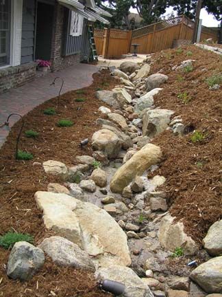 Dry Riverbed Landscaping On Hill, River Rock Drainage Ditch, Rock Landscaping Ideas Front Yard Drought Tolerant Dry Creek Bed, Rock Drainage Flower Bed, Rock Stream Garden Dry Creek, River Rock Landscaping Dry Creek Bed Rain Garden, Dry Riverbed Landscaping, Rain Garden Design, Backyard Drainage