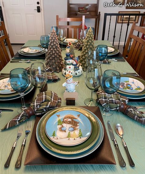 A Snowman Winter Tablescape, table setting, snow, Pfaltzgraff snowmen, pine trees, evergreens, more information about everything on this table in my blog post about it all here: https://www.whispersoftheheart.com/blog/2022/1/14/a-snowmen-winter-tablescape Whispers Of The Heart, Wood Place Card Holders, Table Pieces, Winter Tablescapes, Green Dinner Plates, Small Snowman, Halloween Tablescape, Green Tablecloth, Christmas Elements