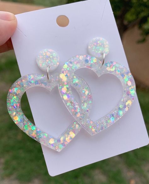 "Each pair of earrings are handmade to order, therefore no two pairs are identical! However, I try to get as close as possible :) Made with non-toxic stainless steel studs Nickel free and hypoallergenic. Heart width is approximately 1.75\", and has white chunky holographic glitter ✨ The circle stud portion of the earring is white with holographic glitter.  These dangly clear holographic heart drop stud earrings are super beautiful and shiny! Perfect for a subtle pop of rainbow! 🌈  Thanks for vi Diy Resin Earrings, Accessories Kawaii, Big Statement Earrings, Diy Earrings Polymer Clay, Resin Jewelry Diy, Kawaii Gifts, Statement Accessories, Glitter Earrings, Heart Stud Earrings