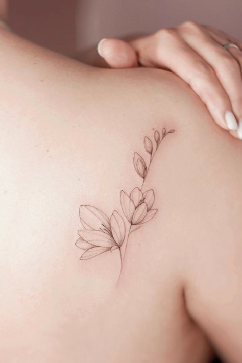 Best Magnolia Tattoos: Ideas, Designs, and Meanings Magnolia Tattoo Back, Dainty Magnolia Tattoo, Magnolia Tattoo Fine Line, Japanese Magnolia Tattoo, Flower Tattoo Magnolia, Magnolia Branch Tattoo, Small Magnolia Tattoo, Magnolia Tattoo Simple, Magnolia Tree Tattoo