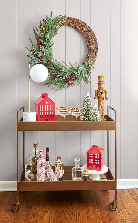 Don't leave your bar cart out of the Christmas decorating fun! Top your cart with a wooden nutcracker, a red house statue, and bottle brush trees. Finish the Christmas display with a simple greenery wreath. #christmasdecorideas #christmasdecorations #christmas #holidayideas #bhg Christmas Bar Cart, Holiday Bar Cart, Canadian Christmas, Holiday Decorating Ideas, Christmas Entry, Christmas Decorations Apartment, Christmas Apartment, Christmas Decorating Ideas, Bathroom Decorating