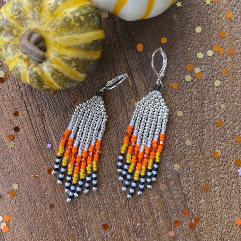 💌 DESCRIPTION Handmade fringe earrings for Halloween that reminds us of the famous candy corn! White, Orange and Yellow - YUM! Made with quality glass beads and touches of orange Swarovski crystals to help you shine. The perfect black and white fringe makes these playful and fun. Perfect for Halloween for yourself or for a gift. Total length is 2.5". Made by hand with love 💝, one tiny bead at a time, by me.   Listing is for ONE pair of cute earrings. ✨✨Click here to view my other earrings   https://etsy.me/3B4ZpTH 💌 SIZE 2.5" Length 0.5" Wide 💌 COLORS Silver White Orange Yellow Black 💌 MATERIALS Quality glass seed beads Genuine Swarovski Crystals Silver plated ear wires 💌 PROCESSING . TIME Most pieces are already made and ready to ship. On occasion, I will need to make you one from s Thanksgiving Seed Bead Earrings, Halloween Seed Bead Earrings, Fall Beaded Earrings, Fall Beaded Jewelry, Halloween Beaded Earrings, Halloween Earrings Beaded, Candy Corn Earrings, Fall Bead, Diy Seed Bead Earrings