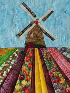 Art quilt with an a Dutch wind mill and tulip fields. Handmade quilt, size