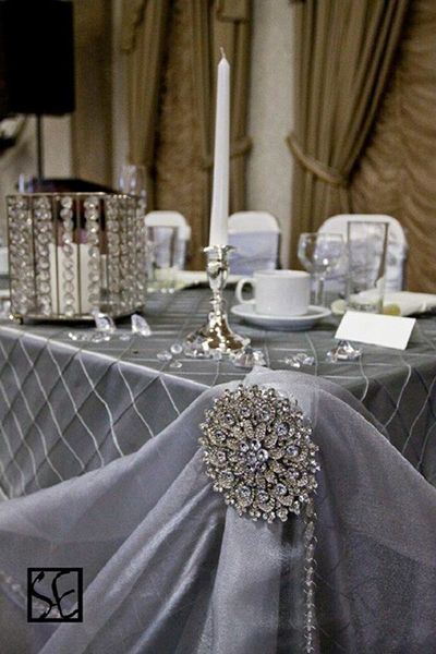 A gorgeous rhinestone brooch adds instant glamour to a silver-hued tablescape. Sparkly Wedding Decor, Silver Tablecloth, Sequin Table Runner, Head Tables, Sequin Table, Sparkly Wedding, Gold Wedding Cake, 25th Wedding Anniversary, Bling Wedding