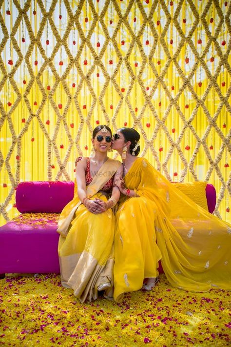 Photo of Two sisters pose together on the haldi ceremony Mehndi Setup, Wedding Packing, Haldi Decor, Haldi Function, Bridesmaid Photoshoot, Haldi Outfit, Sister Poses, Bridal Photography Poses, Desi Wedding Decor