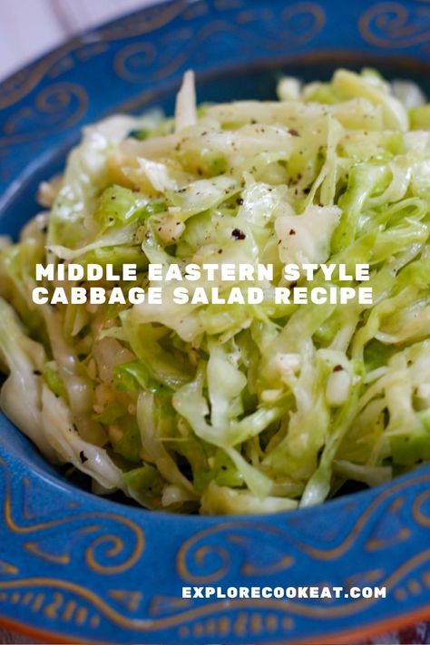 A blue patterned dish containing shredded green cabbage with sprinklings of pepper.