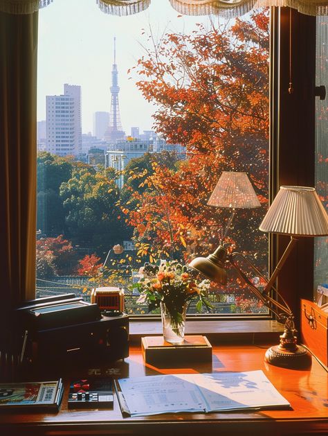 🍂✨ Step back in time to a luxurious living room in 1980s Tokyo! Imagine lounging in a high-class apartment with stunning views of vibrant maple leaves and the iconic Tokyo Tower. From the vintage wooden desk adorned with a lamp and old telephone to cherished comics and video games, every detail whispers nostalgia. 🌸📞 The warm glow of natural light on Kodak film captures the cozy atmosphere perf... Tokyo Fall Aesthetic, Living In Tokyo Aesthetic, Japanese Old Money, Desk Under Window, Desk By Window, Tokyo Luxury, Tokyo Apartment, Old Telephone, Vintage Wooden Desk