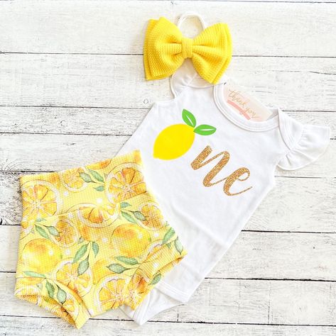 "Baby Girl 1st Birthday Outfit - Lemon First Birthday Bummies- Smash Cake Outfit - Lemon Birthday Outfit This trendy high waisted bummies short and bodysuit set are sure to be a huge hit on your little one's big day! You may choose: ~Flutter sleeve bodysuit as shown. \"One\" with lemon design. ~Adorable lemon themed high waisted bummies/bloomers as shown. ~Darling matching fabric bow/headband as shown. Christi Creations - creating happy moments one bummie at a time! Check out other items in our Lemon First Birthday, Lemon Fabric, Lemon Birthday, Sunshine First Birthday, Smash Cake Outfit, 1st Birthday Outfit Girl, Birthday Skirt, Cake Outfit, First Birthday Outfit Girl