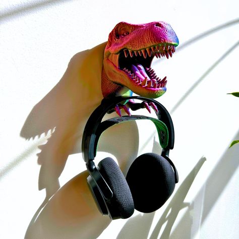 🦖 Step into the Jurassic era with a twist! 🌟 Meet our T-Rex Wall-Mounted Holder, the perfect blend of fun and function for your space. Who said organization has to be boring? Not us! Say goodbye to mundane and hello to magnificent with this beautifully detailed, 3D-printed T-Rex head that's ready to guard your essentials. 🎧🔑 🛠️ Hassle-free installation means you'll go from chaos to organized in minutes. This dino doesn't just hold your stuff—it captivates the imagination and turns any room i... Dinosaur Head Wall Mount, Dinosaur Head, T Rex Dinosaur, Dinosaur Gifts, Dinosaur Wall, Key Hanger, Support Mural, Unique Home, Room Themes