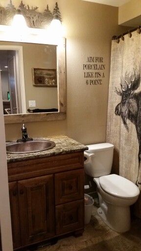 Rustic moose bathroom. Pallet mirror frame, copper sink, moose shower curtain, moose lighting, vynil wall sign. Aim for porcelain like its a 6 point. Hunting Bathroom Ideas, Hunting Theme Bathroom, Wilderness Bathroom Decor, Deer Bathroom Ideas, Woodland Bathroom, Cabin Bathroom Shower Curtains, Deer Hunting Bathroom Decor, Hunting Bathroom Decor, Hunting Bathroom