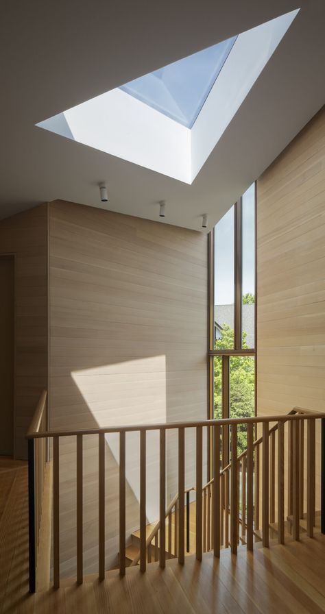 A triangular skylight and narrow window spotlight this contemporary, wood-wrapped landing. Modern track lights blend into the white ceiling, which offers the illusion of height. Maine Interiors, Skylight In Kitchen, Narrow Window, Landing Decor, Modern Track Lighting, Stair Ideas, Skylight Kitchen, Muji Style, Track Lights