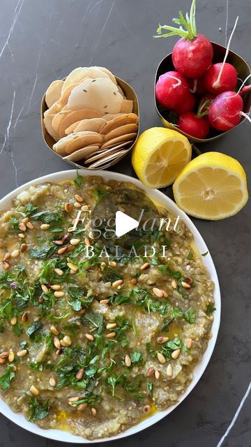 Sivan's Kitchen on Instagram: "EGGPLANT BALADI🍆🧄🍋 
Classic middle eastern dip with a rich and Smokey flavor.  One of my favorite Shabbat staples 👌 

 Ingredients
* 2 large eggplants
* 4 cloves garlic, minced
* 2 tablespoons lemon juice (about one lemon)
* 3 tablespoons olive oil
* Salt to taste
* Fresh parsley and mint, chopped, for garnish
* Toasted pine nuts for garnish (optional)
* Warm pita bread, crackers,  or vegetables, for serving. 

Directions:
1. Roast the Eggplants:
 * Preheat your oven to 400°F (200°C).
 * Pierce the eggplants a few times with a fork to prevent them from bursting in the oven.
 * Place the eggplants on a baking sheet and roast them for about 45-60 minutes, turning occasionally, until the skins are wrinkled and the flesh is very soft.
 * Alternatively, for a Eggplant Dip, Middle Eastern Dishes, Toasted Pine Nuts, Fresh Parsley, Dinner Tonight, Middle Eastern, Eggplant, Garlic Cloves, Vegan Vegetarian