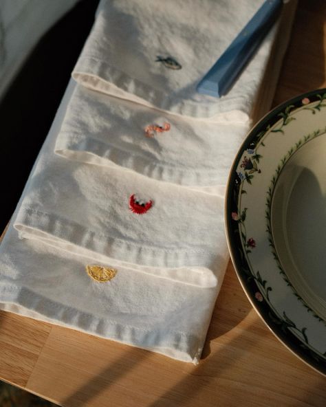 what’s for dinner 🍋🦀🦐🐟 v into hand embroidered dinner napkins at the moment. These little guys served as stitch studies before my big spring embroidery project 🐙 currently scheming up my next…pasta theme for a special dinner napkin set is on deck! 🍝 PS must shout out the original inspiration for these. I referenced a set by Sew Bella I saw on maisonflaneur.com while hand embroidering mine :) #handembroiderywork #handembroiderednapkins #dinnernapkins #coastalgrandma #embroiderylover #dmcem... Embroiled Napkins, Wedding Table Embroidered Napkins, Embroidered Table Linen, Embroidered Dinner Napkins, Linen Placemats Embroidery, Spring Embroidery, Embroidered Napkins, Special Dinner, Sewing Studio