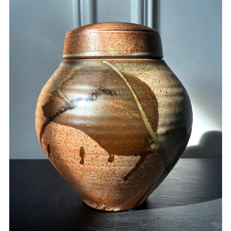 A ceramic (earth ware) lidded jar with glazed surface by American studio potter Karen Karnes (1925-2016). The mark on the jar indicates that the piece was made circa 2000s. The wheel-thrown piece shows off a beautiful form with a swell body and harmonious proportion, reminiscent of the vernacular jars one would find in Asian kitchens for fermenting and storage. The surface is covered with an orange color shino-like glaze and painted with abstract strokes, which clearly inspired by Japanese Minge Lidded Container Ceramics, Lidded Ceramics, Lidded Pottery, Sun Burn, Asian Kitchen, Pottery Jar, The Jar, Ceramic Jars, Ceramic Studio