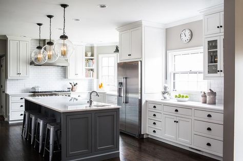 White and gray kitchen features white cabinets adorned with bronze cup pulls and knobs paired with white quartz countertops and a white subway tile backsplash. Grey Island, Gray Island, Серая Кухня, Grey Kitchen Island, House Farm, White Kitchen Remodeling, White Kitchen Design, Kitchen Farmhouse, Transitional Kitchen