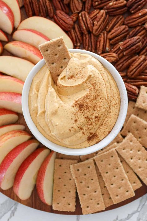 Easy no bake pumpkin cheesecake dip is a fall favorite. Pair with apple slices, graham crackers, pecans, pretzels, ginger snaps, nilla wafers and more! This simple recipe also makes a great spread for french toast and pancakes. I love serving pumpkin dip during spooky season and at holiday parties. It's great for Halloween, Thanksgiving and even Christmas! This cold dip is basically dessert but it's the best healthy option, sweetened with just a touch of maple syrup and no refined sugar. Homemade Pumpkin Cream Cheese, Fall Cookie Dip, Pumpkin Apple Dip, Dairy Free Pumpkin Dip, Dips For Apple Slices, Apple Butter Dip, Fall Dip For Apples, Cream Cheese Dip For Graham Crackers, Pumpkin Cream Cheese Spread