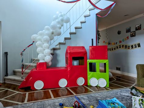 Cardboard train made for a train themed 3 years old party with a balloon arch for a smoke stack. Cardboard was covered in solid colored wrapping paper for the color. Masking tape on the floor made DIY train tracks. Diy Train Tracks On Floor, Train Party Balloon Arch, Train Balloon Arch, Diy Train Tracks, Cardboard Train, Diy Train, Trains Birthday Party, Train Party, Train Birthday