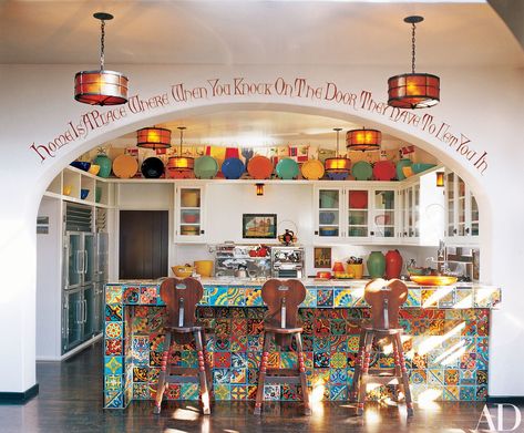 An adapted Robert Frost quote frames the kitchen, brightened by vintage California tile and a 1950s chrome O’Keeffe & Merritt range. “We were driving around L.A. one day,” Shadley says, “and Diane saw the stove in a store window and said, ‘Wait! Turn around and go back!’” Hacienda Kitchen, Celebrity Kitchens, Monterey Furniture, Fiesta Kitchen, Spanish Kitchen, Colorful Pottery, Mexican Kitchens, Angela Lansbury, Fiesta Dinnerware