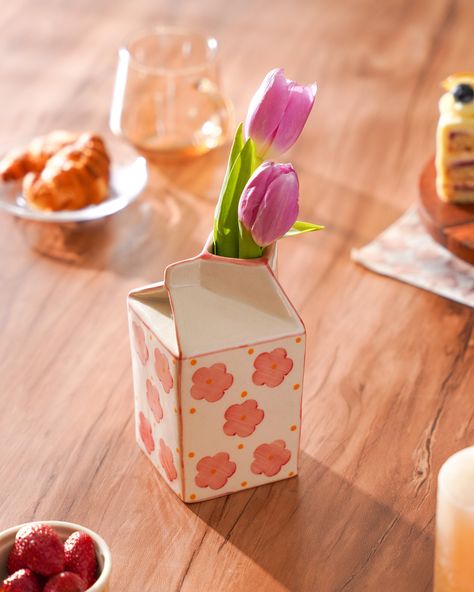 Add a touch of whimsy to your home with this charming ceramic milk carton vase, beautifully hand-painted with delicate pink flowers. This quirky and unique flower pot is a perfect conversation starter and an ideal gift for any occasion. Details: Volume: 525 ml Dimensions: 3 inches (length) x 3 inches (breadth) x 6 inches (height) Material: High-quality ceramic Craftsmanship: This vase is meticulously crafted by skilled artisans using traditional techniques. The piece undergoes a bisque firing pr Ceramic Milk Carton, Unique Flower Pots, Unique Vase, Daisy Painting, Unique Centerpieces, Ceramic Flower Pots, Milk Carton, Vase Shapes, Unique Vases