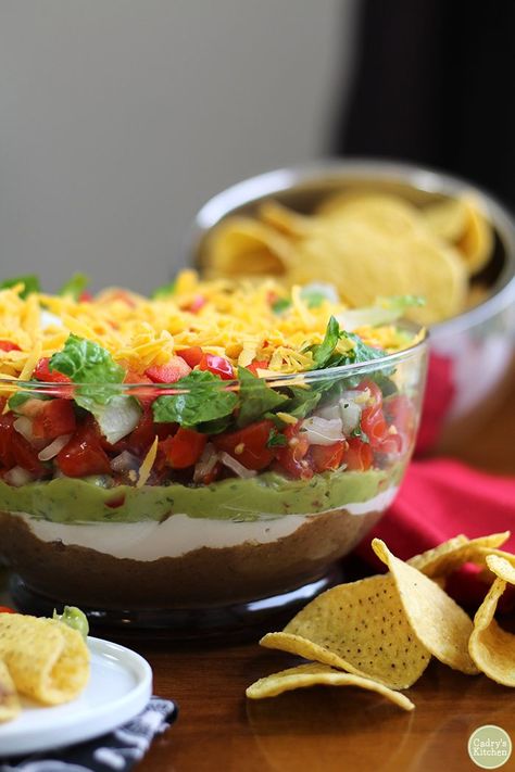 Vegan 7 layer dip in glass bowl with tortilla chips. Dishes For Potluck, Party Food For A Crowd, Favorite Party Appetizers, Gluten Free Party Food, Gluten Free Party, 7 Layer Dip, Vegan Appetizers Recipes, Homemade Refried Beans, Vegan Potluck