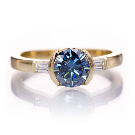 Fall in love with the half-bezel set round blue moissanite Harper engagement ring with baguette diamond accents. This 3 stone engagement ring features a stunning blue moissanite center in a modern semi-bezel setting with bar set baguette diamond side stones. https://nodeform.com/products/harper-ring-round-blue-moissanite-baguette-accented-half-bezel-engagement-ring Half Bezel Engagement Ring, 3 Stone Engagement Ring, Half Bezel Setting, Baguette Engagement Ring, Half Bezel, Blue Moissanite, Bezel Engagement Ring, 3 Stone Engagement Rings, Ring Shank