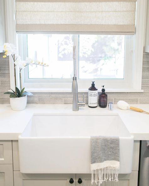 Kitchen with apron sink and light beige roman blinds over window behind sink Roman Shade Kitchen Window, Beige Roman Blinds, White Kitchen Windows, Roman Blinds Kitchen, Roman Shades Kitchen, Kitchen Shades, Linen Roman Shades, Bathroom Window Treatments, Window Treatments Living Room