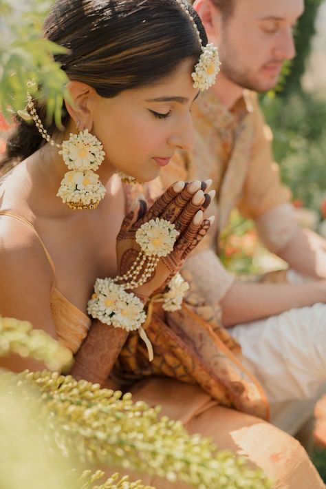 This couple celebrated their Hindu-Catholic tuscany wedding ceremony in the romantic Italian countryside | Vogue India Haldi Look For Bride, Flower Jewellery For Haldi, Flower Jewellery For Mehndi, Fresh Flower Jewelry, Haldi Ceremony Outfit, Catholic Wedding Ceremony, Flower Jewelry Designs, Wedding Flower Jewelry, Hindu Wedding Ceremony