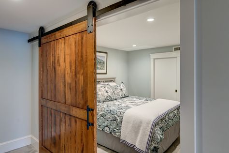 Sliding barn door creates privacy in a basement bedroom. Finished Basement Guest Room, Basement Bedroom With Ensuite, Small Basement Guest Bedroom Ideas, Tiny Basement Bedroom, Basement Guest Bedroom No Window, Small Basement Guest Room, Basement Bedroom Ideas On A Budget, Basement Guest Bedroom, Ideas For Basement