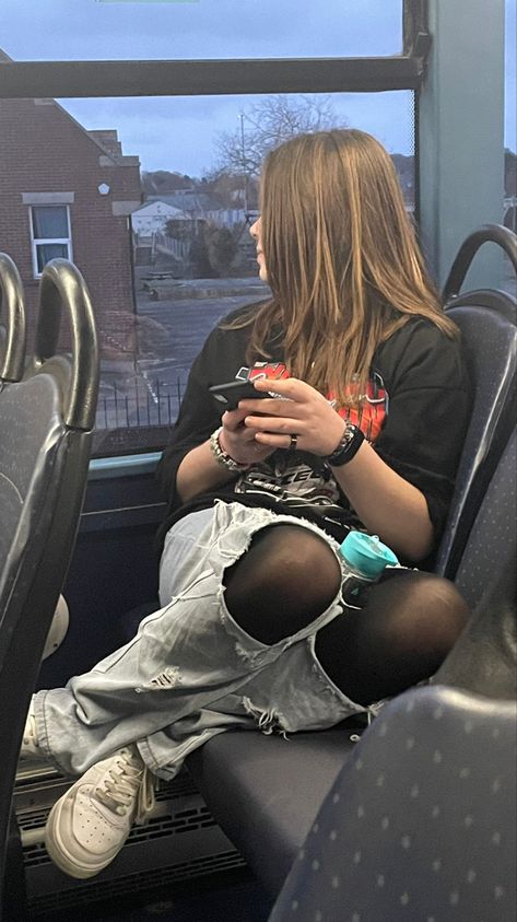 A girl on a bus wearing a large shirt,baggy ripped jeans with tights underneath. She holds a iPhone and looks out of the window. Jeans Pantyhose Outfit, Tights Under Shorts Outfits, Tights Under Jeans, Pantyhose Outfit, Black Tights Outfit, Tights Outfits, Trendy Date Night Outfit, Legs Outfit, Pantyhose Fashion