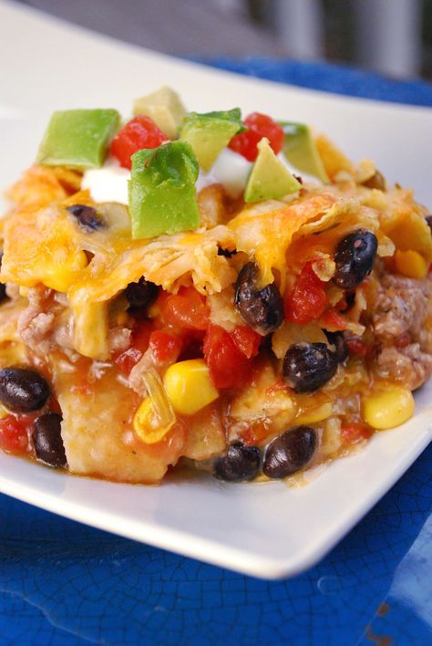 This easy nacho casserole is loaded with beef, black beans, cheese and green chili sauce. Kid friendly recipe for a quick weeknight dinner idea! Easy Beef Nachos, Nacho Casserole, Chili Nachos, Easy Taco Casserole, Easy Mexican Casserole, Beef Nachos, Baked Nachos, Green Chili Sauce, Easy Nachos