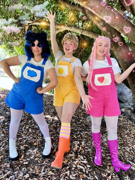 Care Bears!! Halloween Costume inspo! Grumpy Bear, Sunshine Bear and Love-a-Lot Bear! Dress up with your friends this Spooky Season!! Trick-or-treat friendly costume Trunk Or Treat Costumes, Carebares Costume, Preppy Care Bear Halloween Costume, Carebear Costume Diy, Care Bear Halloween Costume, School Friendly Halloween Costumes, Care Bear Cosplay, Care Bears Costume, Carebears Costume Group