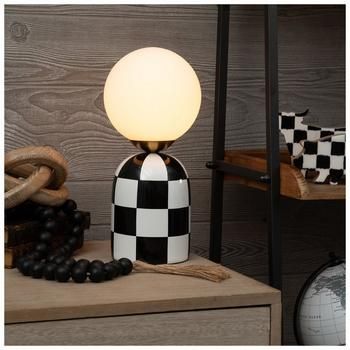 Base Dimensions: 5.75" W x 5.75" D Shade Dimensions: 6" H x 6" W x 6" D Full Height: 12" Cord Length: 60" Bulb Type: B 3W Power Source: Corded Electric Material: Ceramic, Glass & Metal Color: Black, White & Gold Pattern: Check Quantity: 1 Invite a timeless classic into your home with a Checkered Table Lamp. This ceramic lamp features a retro check design and a round bulb on top. The large bulb on top gives this accent a modern twist to an otherwise vintage design. Place it in your living room to Hobby Lobby Lamp, Funky Lamp Shade, Unique Desk Lamp, Electric Decor Style, Checkered Room Decor, Black White And Gold Living Room Ideas, Dark Vintage Home Decor, Checkered Lamp, Ugly Apartment Decorating