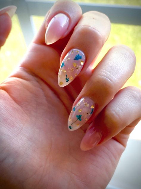 Floral nails with small blue and nude flowers and flecks of gold with a pink nude backing Nude Nails With Blue Flowers, Light Blue Floral Nails, Clear Floral Nails, Floral Nails Blue, Nude Floral Nails, Wild Flower Nails, Blue Floral Nails, Midi Haircut, Nail Art Fleur