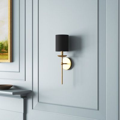 This 1-light wall sconce features a simple sleek look with a flower-like bobeche beneath the linen shade. The finish creates consistent cool. This sconce looks great when used solo or in groupings! 18.5" in height, 5" in width, and extends 6.25" from the wall. Max 60-watt bulb, candelabra size C11 bulb recommended. LED bulb compatible. Damp area rated. Birch Lane™ Finish: Gold, Shade Color: Black Birch Lane™ Olivette 1 - Light Dimmable Wallchiere - Wall Sconces in Gold/Black | Size 18.5" H X 5" Sconces Above Couch, Wall Sconces Living Room, Black Sconces, Wreath Wall Decor, Sconces Bedroom, Bathroom Sconces, Classic Wall, Bedside Lighting, Metal Mirror