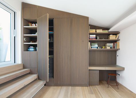 A vintage stool, a design that once was a staple of Greek classrooms, is tucked under the office desk on a landing leading to a balcony. The visual theme of the vertical wooden slats repeats itself here, including on a closet door. “They have no handles,” Ritenour says of the closet doors. “The lines are the door handles; you have to know to grab them.” Smart Living Room, Modern Penthouse, Shiplap Wall, Light Hardwood Floors, Vintage Stool, Interior Wall Decor, Closet Door, Hidden Door, Slat Wall