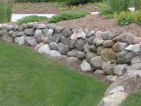 I like the size of these boulders as our rock wall at the lake. Rip Rap Retaining Wall, Rock Wall Gardens, Stone Walls Garden, Landscaping A Slope, Small Yard Landscaping, Landscaping Retaining Walls, Hillside Landscaping, Easy Landscaping, Sloped Garden