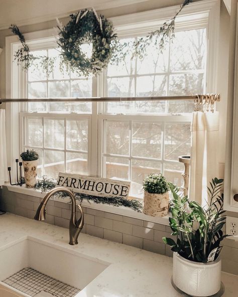 This farmhouse kitchen features a white window with cream cafe curtains above a white sink with nickel faucet. The faucet is mounted to a white and gray countertop in front of gray subway tile backsplash. Kitchen Curtain Ideas Above Sink, Kitchen Window Decor Over Sink, Kitchen Window Above Sink, Kitchen Windows Above Sink Ideas, Kitchen Windows Above Sink, Kitchen Window Curtains Over Sink, Curtains For Kitchen Window, White Kitchen Windows, Kitchen Curtain Ideas