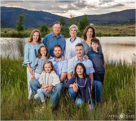 A family wearing shades of blue and white pose for a classic family portrait with a pretty pond and blue mountains in the backdrop at Eagle River Preserve in the Vail Valley of Colorado during summer. - April O'Hare Photography http://www.apriloharephotography.com Grandma And Grandkids Poses, Family Photo Outfits Summer, Silverthorne Colorado, Extended Family Photography, Family Portrait Outfits, Summer Family Pictures, Hare Photography, Big Family Photos, Extended Family Photos