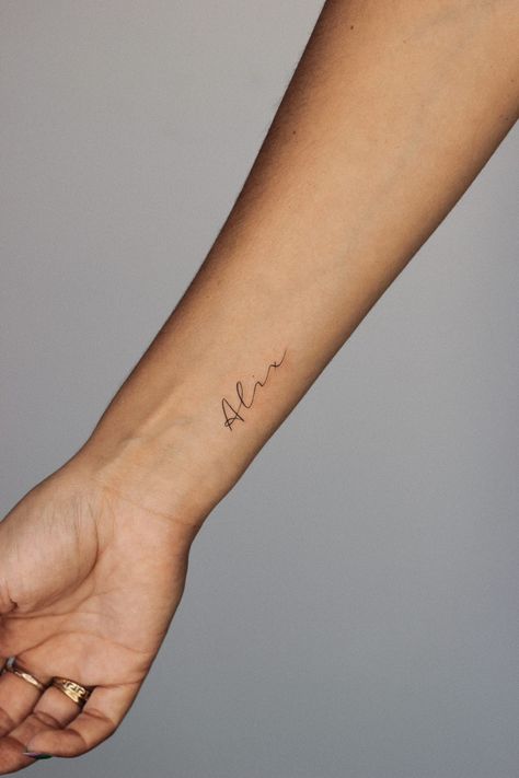 Wrist tattoo small fineline name alix Dainty Last Name Tattoo, Middle Name Tattoo Ideas, Childs Name Tattoo Placement, Meet Name Tattoo, Madden Name Tattoo, Dainty Tattoo For Son, Tattoo For Daughter Name, Names On Wrist Tattoos, Script Name Tattoo Forearm