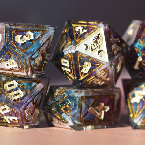 Here's something a little new that I've been working on! These are some new blanks that I bought. I'm in LOVE with stained glass and intricate dice faces (which, I admit, maaay be slightly obvious from my feed). These dice blanks are cast, sanded and inked, then submerged in a shell-layer that gives the dice their numbers! This set is 10 pieces, the standard 7 plus an extra D20, a crystal D6 and a D2 :) This set was possible with masters from @atomic.dice and @druid_dice <3 #dice #dicese... Resin Dice, Dnd Dice, I'm In Love, Juno, Frosted Glass, 7 Plus, Stained Glass, In Love, It Cast