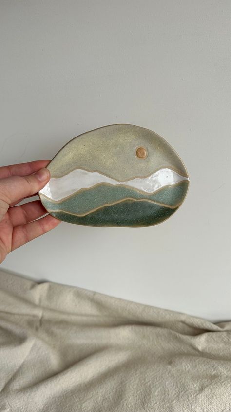 Hand made ceramic trinket dish. Landscape pattern in white, blue and green glazes. This is a 'one of a kind' item handmade by me in Derbyshire studio, and as such every trinket dish will be slightly different in shape and size. Width | Roughly 13cn This plate is completely handmade so the slight lumps and bumps and imperfections only add to the charm! There are imperfections in the glaze finish that do not detract from the beauty of the piece.  Please note I make my ceramics to order, so will ta Landscape Pottery, Pottery Easy, Ceramic Jewelry Dish Handmade, Pottery Painting Trinket Dish, Ceramic Pieces, Cute Pottery Ideas, Ceramic Painting Trinket Dish, Trinket Dish, Face Trinket Dish