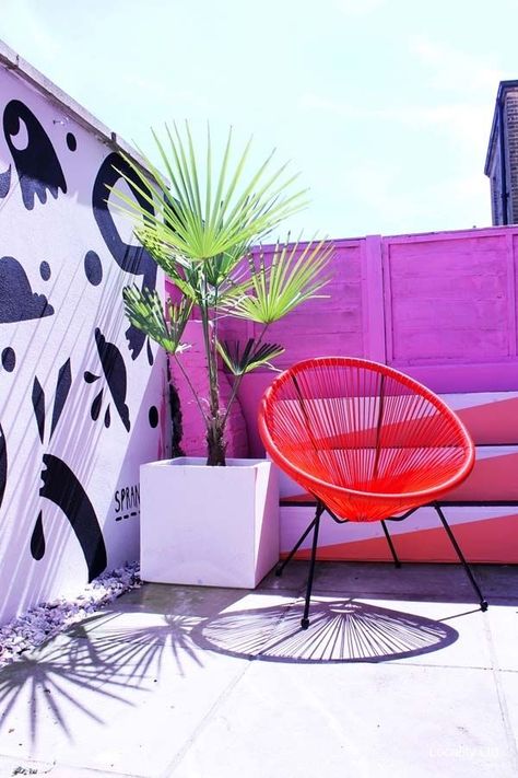 Bright coloured courtyard garden. Bright pink fence with graffiti wall. Orange chair and potted plants. Great idea for small courtyard gardens. #outdoorliving #colourfuloutdoorliving #kidsoutdoorliving #colourfulfurniture #backyardfurniture Pink Fence, Wall Orange, Small Courtyard, Courtyard Gardens, Garden Mural, Orange Chair, Small Courtyard Gardens, Courtyard Gardens Design, Small Courtyards