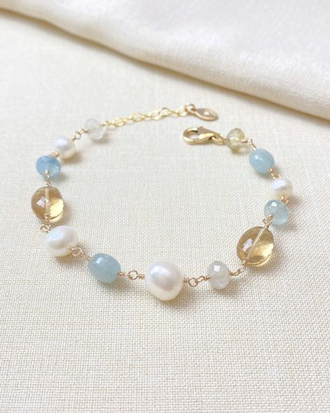 This artisan-crafted bracelet contains beautiful warm and cool-colored gemstones paired with white pearls for an elegant fall look. Each hand-picked gemstone and pearl is meticulously wire-wrapped in gold fill for a timeless look. This piece looks great on its own, but easily stacks with other favorite bracelets. Bracelet length:  7 inches plus 1 inch extender MATERIALS ~ Champagne quartz ~ Golden rutilated quartz ~ Aquamarine ~ Cultured freshwater pearls ~ Gold fill GIFTING ~ Jewelry gift box included. ~ I am happy to ship directly to the recipient.  Enter their address during checkout. ~ If you would like a gift note included in the package, please leave the text of the note in the "Add a note to Marsh Creek Jewelry" message box at checkout. FREE SHIPPING ~ Orders ship within 2 business Wire Wrapped Gemstone Jewelry, Wire Clasp, Pearl Beaded Bracelet, Golden Quartz, Ladies Bracelet, Golden Rutilated Quartz, Colored Gemstones, Elegant Fall, Handcrafted Bracelets