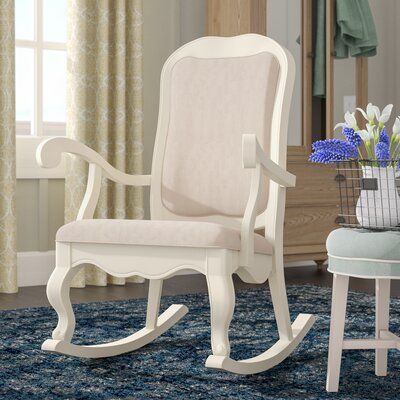 A French country update on a traditional design, this elegant rocking chair lends Provencal charm to any seating ensemble. Crafted of solid rubberwood in a cottage white finish, this chair features a full, arched back, curvy arms, a scalloped apron, cabriole legs, and curved gliders. Light beige fabric upholstery envelops the seat and accents the backrest, while cushioned padding provides comfortable support. Measuring 42.74"H x 29.13" W x 32.75" D overall, this chair is compact and easy to move Farmhouse Rocking Chair, White Rocking Chairs, Sofa Santai, Wood Rocking Chair, French Provincial Style, Nursery Furniture Sets, Brown Living Room, Wooden Sofa, Beige Fabric