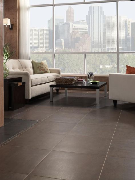 Particularly popular these days, he adds, are large-format tiles — tiles that come 12" x 24" and even 36" x 36" — as opposed to the tried-and-true 12" x 12" tiles. In addition to looking great, larger sizes mean more tile surface and less grout lines to clean. Dean cautions that large-format tiles are heavy, requiring a perfectly level substrate and a professional installer for the job to come out right. Brown Floor Tiles, Floor For Living Room, New Flooring Ideas, Wood Tile Flooring, Large Floor Tiles, Living Room Floor Tiles, Wood Grain Tile, Floors Ideas, Interior Flooring