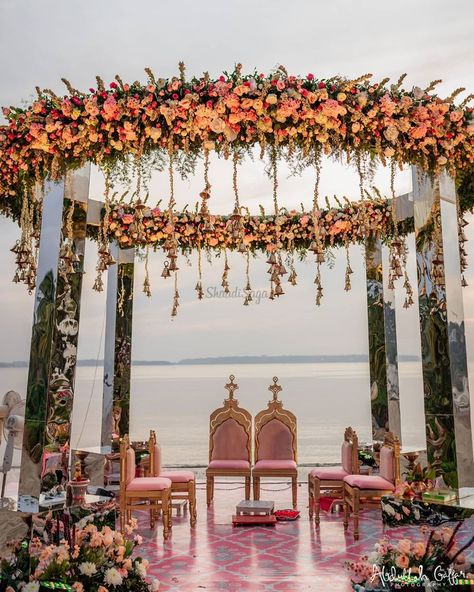 How stunning this unique mandap decor looks. We are absolutely in love with pastel colour flowers on a mirror frame mandap so dreamy and perfect for beach wedding.  #Indianwedding #Indianbeachwedding #shaadisaga #mandapdecorideas #floralmandapdecor #beachwedding #fairytalewedding Indian Beach Wedding, Mandap Design, Goa Wedding, Wedding Setup, Mandap Decor, Desi Wedding Decor, Wedding Mandap, Wedding Design Decoration, Wedding Set Up