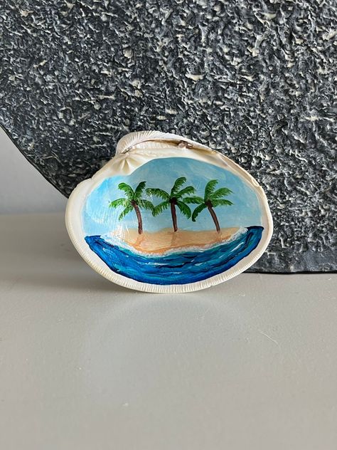 Hand painted clam shell jewelry dish by Sunny Shore Studios. Tropical island with palm trees. Small size perfect for rings or earrings.  Made with acrylic paint, and sealed with a gloss finish to be enjoyed for years to come! Makes a great gift! Great on nightstands, dressers, vanities or in bathrooms. We ship all sales the day as your purchase! Gift cards can be added to your order at no additional charge. If you would like a gift card included in your order please message us. Thank you!  To sh Clam Shell Painting, Painting Shells Ideas, Sea Shell Painting Ideas, Beach Rock Painting, Painting Seashells Ideas, Shell Painting Ideas, Sea Shell Painting, Paint Shells, Painting Seashells