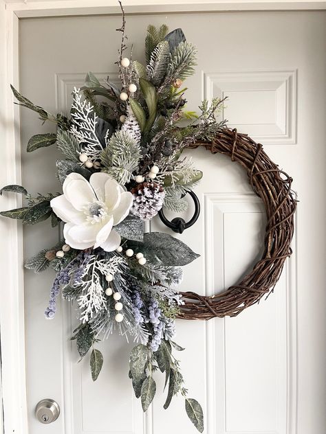 "A gorgeous giant silvery white faux magnolia flower sits on a bed of frosted and flocked silvery blue/green mixed greenery.  This elegant wreath is made with an 18\" grapevine base and ends up being 24\". This winter magnolia wreath could be used for Christmas and all winter long!  Get ready to impress the neighborhood and welcome your guests with this stunner of a wreath.  This wreath would look great hung on your front door or window, or over your mantle, over a table in an entryway or bed.   Wreaths also make great gifts for housewarming, birthdays, weddings, and more! **If you would like a wreath to be customized/changed in any way, please message me and I will do my best to accommodate any special requests! I am always open to new ideas and love working with customers to help you cre Large Winter Wreath, Winter Magnolia Wreath, Magnolia Christmas Tree, January Wreath Ideas, Elegant Christmas Wreaths, Winter Entryway, Diy Topiaries, Winter Wreath Ideas, January Wreath