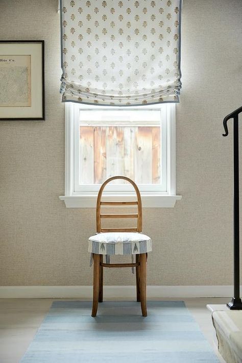 A vintage ladder back chair accented with a skirted seat cushion sits on a blue runner beneath a window covered in a white and blue block print roman shade and framed by gray grasslcoth wallpaper. Grey Grasscloth Wallpaper, Sarah Bartholomew, Blue Block Print, French Headboard, Glass Pocket Doors, Wooden Cribs, Camp House, White Wainscoting, Vintage Ladder